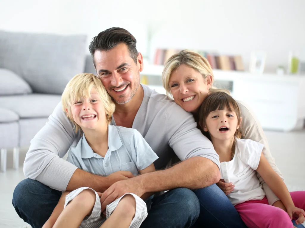 young family smiling together: comprehensive dentist in Monroe, CT